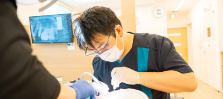 歯周病を改善するために治療を行う歯科医師